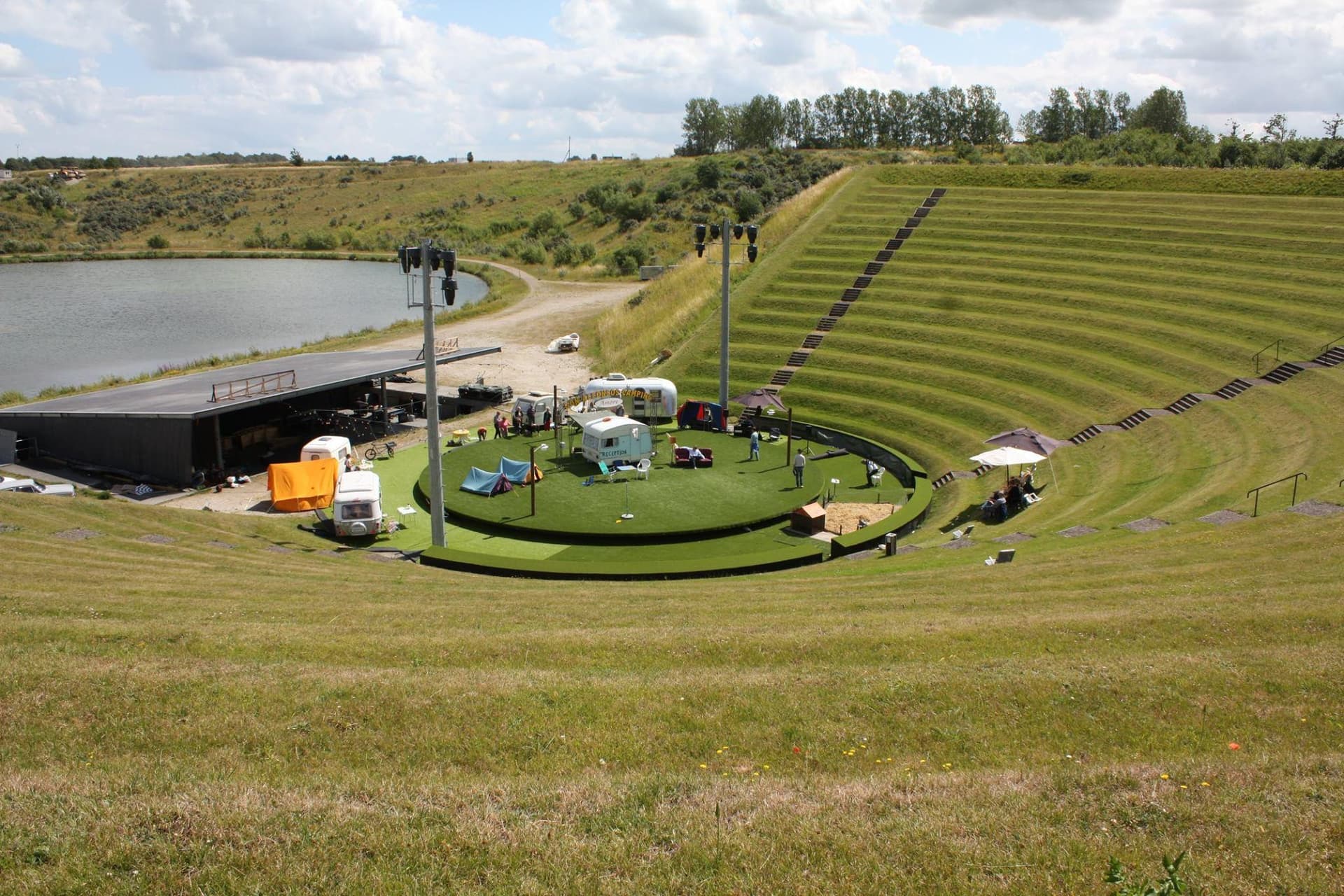 Legeplads med rundkørsel på grønt område ved dam og landsdele