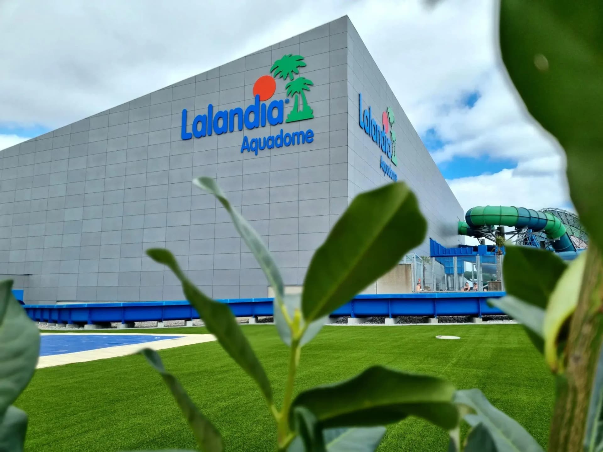 Lalandia Aquadome-bygning med grønt græs og grønne planter i forgrunden