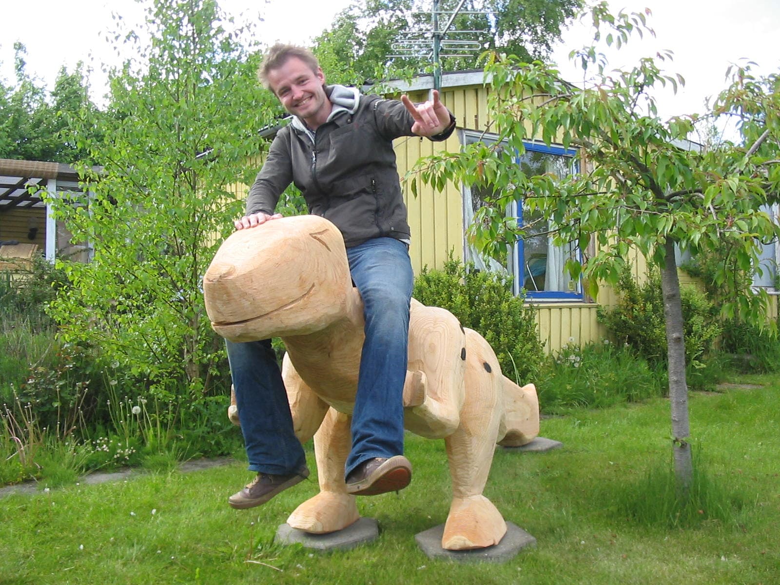 Voksen afprøver balance i dinosaur-skulptur