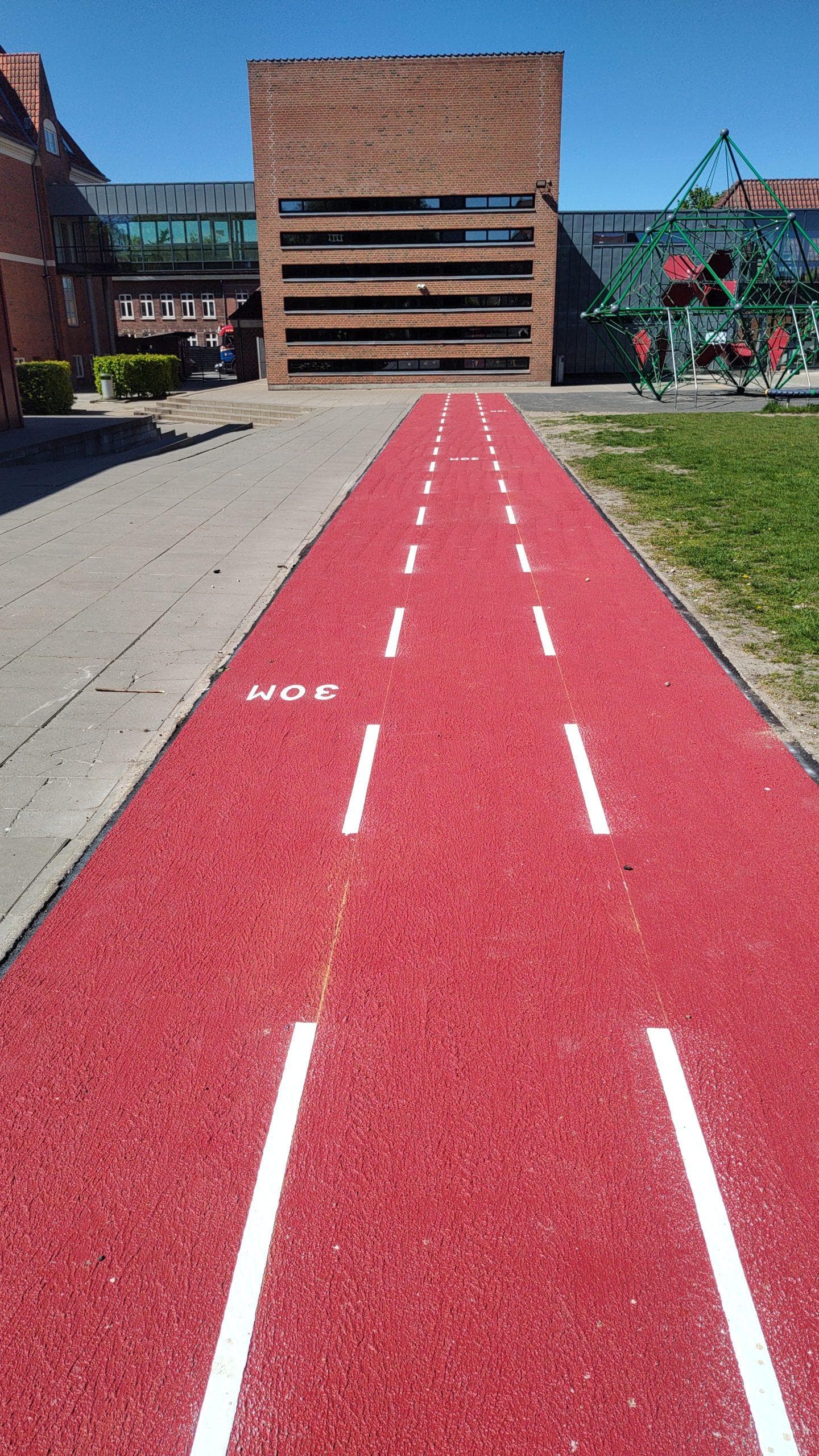 Rød løbebane med hvide baneskel og 30-meter-markering