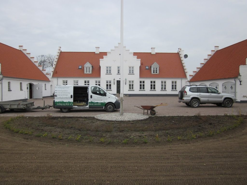 Blomsterbede ved Gimming præstegård med roser og takshæk