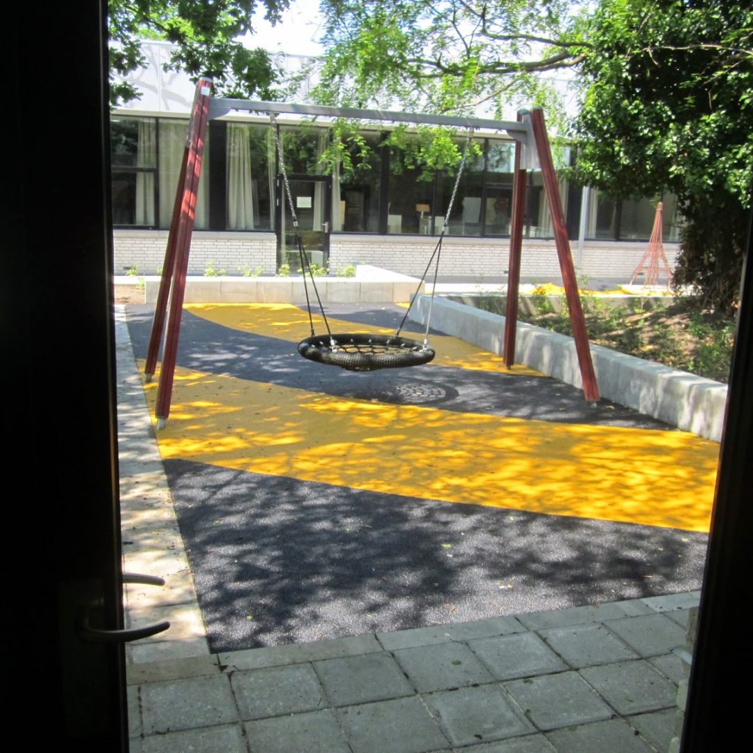 Atriumgård med gynge og gummibakke på Dyvekeskolen